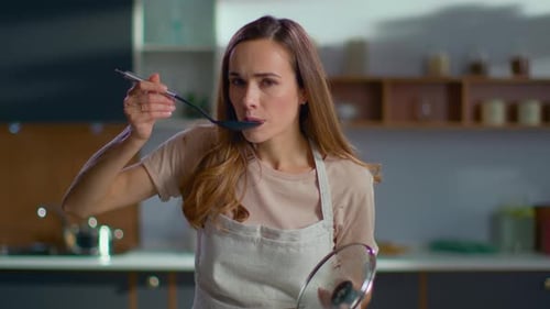 Pretty Woman Cooking Soup on Stove at Kitchen. Close Up of Housewife