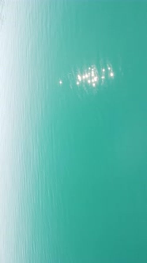 Vertical Aerial View on Sea Water Surface Camera Flies Over Clear Sea Water Sun Glare Abstract