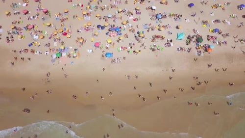 Tropical beach with colourful umbrellas and people enjoying the calm water
