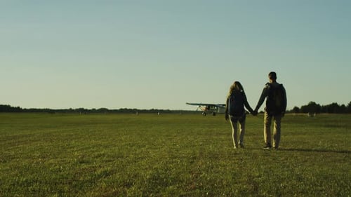 Couple is Moving Towards Airplane in Airfield