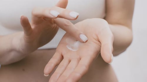 Woman Applying Lotion to Her Hand