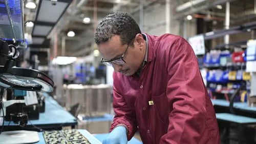 Konzentrierter männlicher Ingenieur, der in der Halbleiterfabrik Accuracy arbeitet