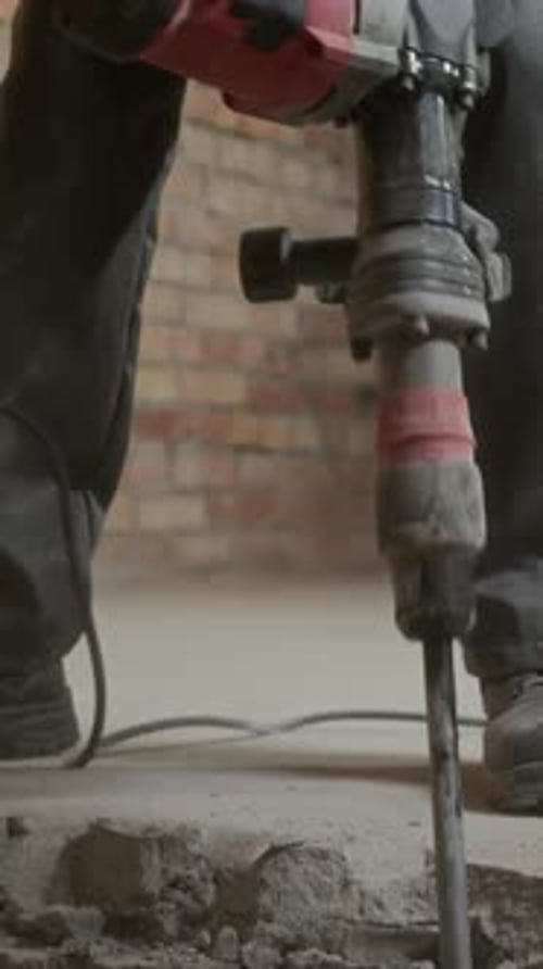 Construction Worker Using Jackhammer Indoors