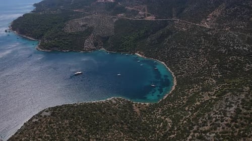 Aerial a Sailing Yacht is Anchored in a Beautiful Bay Among the Mountains