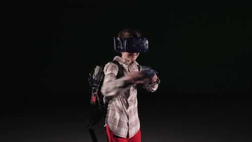 A Teenage Boy Wearing VR Glasses Uses the Headset Helmet App to Play a Simulator