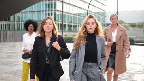 Four Stylish Women Walk Near Modern Office Building