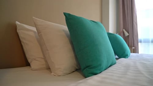 Comfortable Hotel Bed with Pillows and Striped Sheets