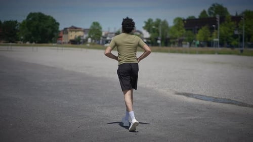 Man Runs in Urban Environment on Sunny Day