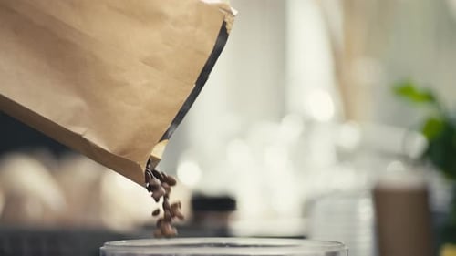 Coffee Beans Pouring From Bag Into Glass