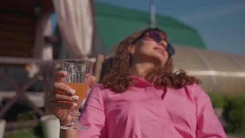Woman Relaxing Outdoors Holding a Refreshing Drink