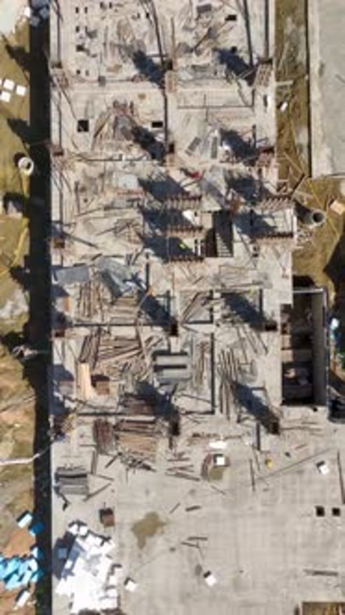 Vídeo vertical: Zona de construcción activa con constructores y máquinas pesadas preparando un nuevo proyecto