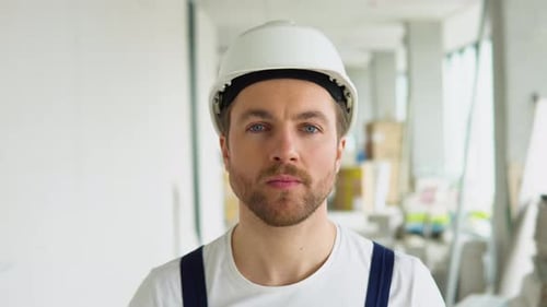 Portrait of a Young Builder on the Construction Site of the Office