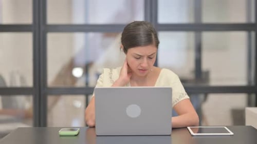 Woman Rubbing Stiff Neck While Working on Laptop