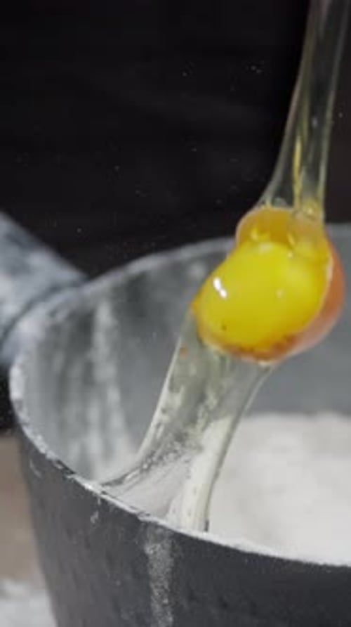Cracking an Egg into Flour for Baking