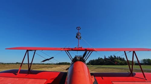 Ein kleines motorisiertes Flugzeug fährt auf einer unbefestigten Landebahn