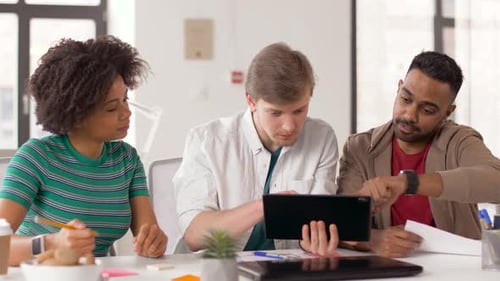 Happy creative team using tablet pc computer working together in modern office