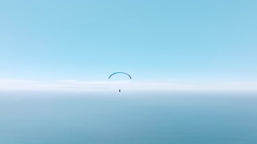 Gleitschirmpilot fliegt mit abenteuerlichem Touristenflug vom blauen Himmel zum Horizont