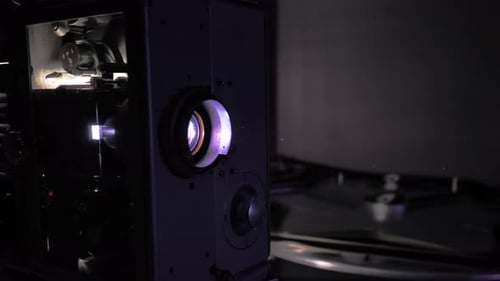 Vintage Film Projector Projecting Movie in Dark Room