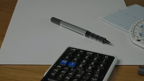 Calculator, Pen, and Ruler on White Paper