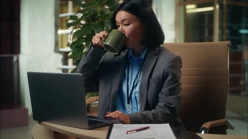 Empresaria alegre, segura de sí misma, asiática, china, japonesa, sosteniendo una taza de café bebiendo, sonriendo