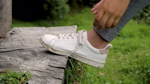 detail of a runner's foot adjusting her laces