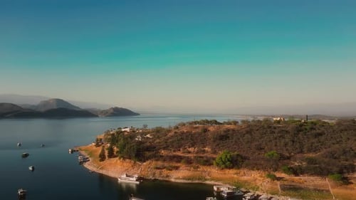 Aerial drone flying over a lake, water dam, with mountains at sunrise. Beautifull dreamy landscape