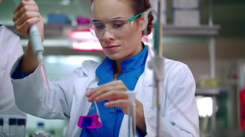 Woman Scientist Working with Pipette in Laboratory