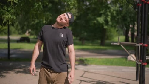 Man Warming Up Neck Before Exercise in Park