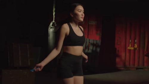 Woman Jumps Rope in Dark Workout Room