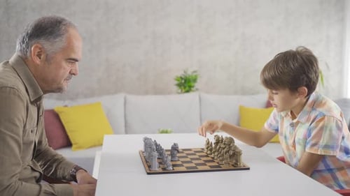 Grandfather and grandson are playing chess.