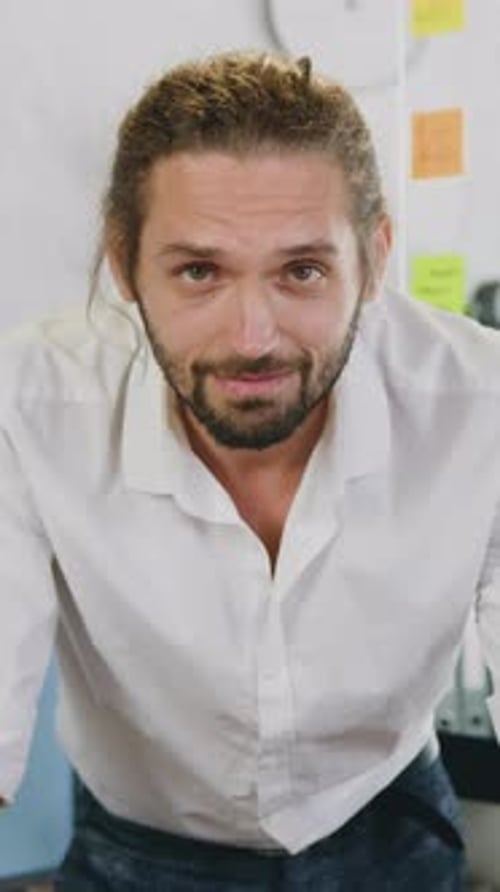 Happy Man With Man Bun Smiles In Vertical Office Video
