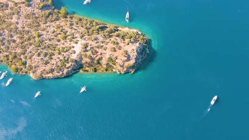 Aerial drone flying over the mediterranean sea with sailing boats, yachts in the bay lagoon. Golden
