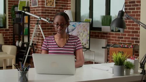 Young Woman Works at Laptop in Home Office