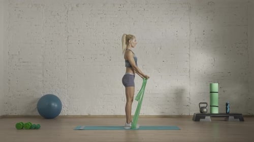 Woman Exercising with Resistance Band in Gym
