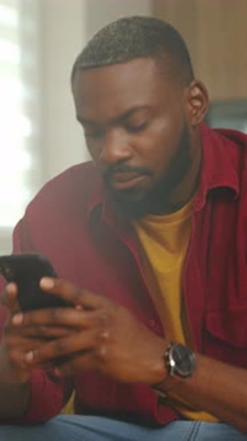 Individual Reviewing Messages on Smartphone Man Leisure Browsing Financial Applications Indoors at