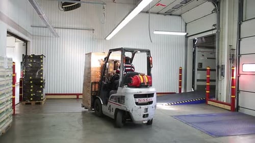 Russia, Novosibirsk - July 25, 2015: Loader Driver Of Transport Company Load And Unload Pallets W...