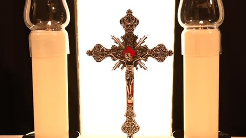 Crucifixo ladeado por velas em um altar