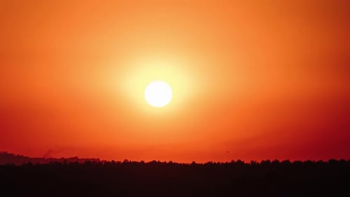 Coucher de soleil impressionnant se déplaçant dans le ciel orange avec un timelapse de nuages doux