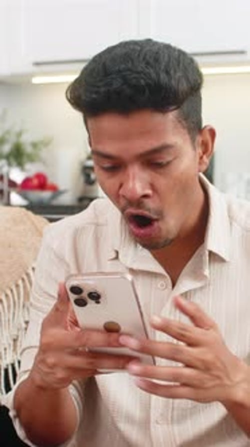 Man Reacts to Good News on Smartphone
