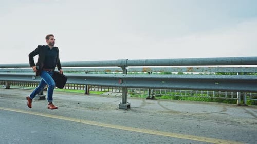 Man Hurries Down the Highway with a Briefcase in Early Morning Light