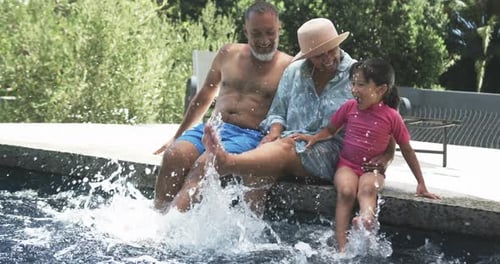 Family Splashing in the Pool on Summer Day
