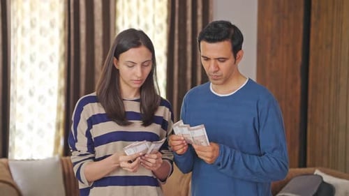 Indian couple counting money and discussing