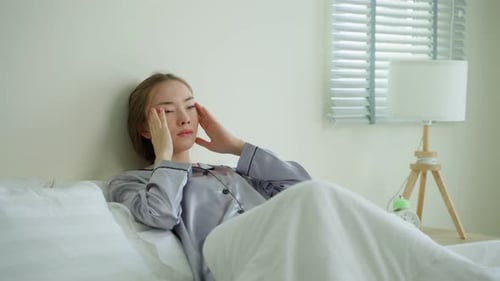 Woman Lying in Bed Experiencing Headache