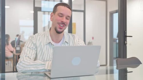 Young Man Has Video Call in Modern Office