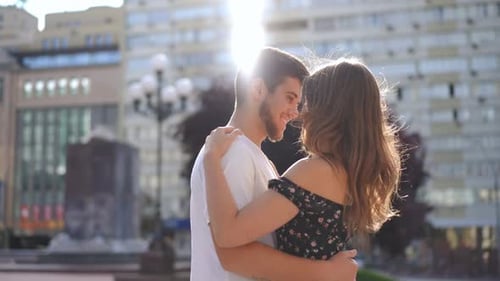 Side View Zoom in to Happy Hugging Couple Talking Standing on City Street