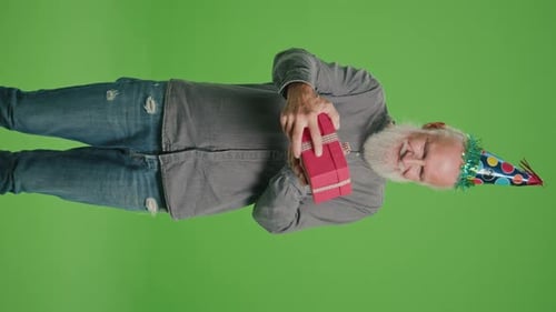 Senior Man with Party Hat Holding Gift