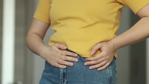 Woman Rubbing Her Stomach in Painful Discomfort