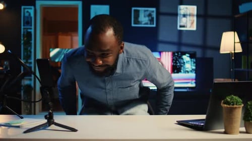 Young Adult at Desk Speaking to Tablet