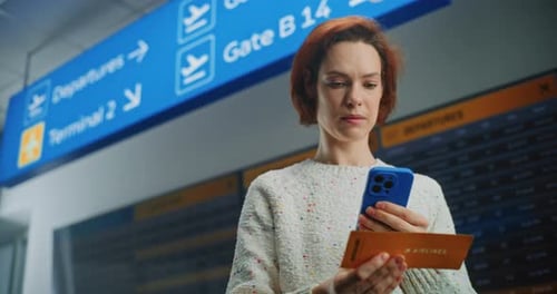Stylish Woman Checking Phone and Ticket in Airport
