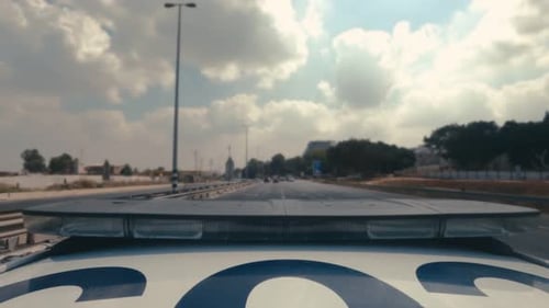 POV shot of a Police car with blue and red lights driving fast through city streets